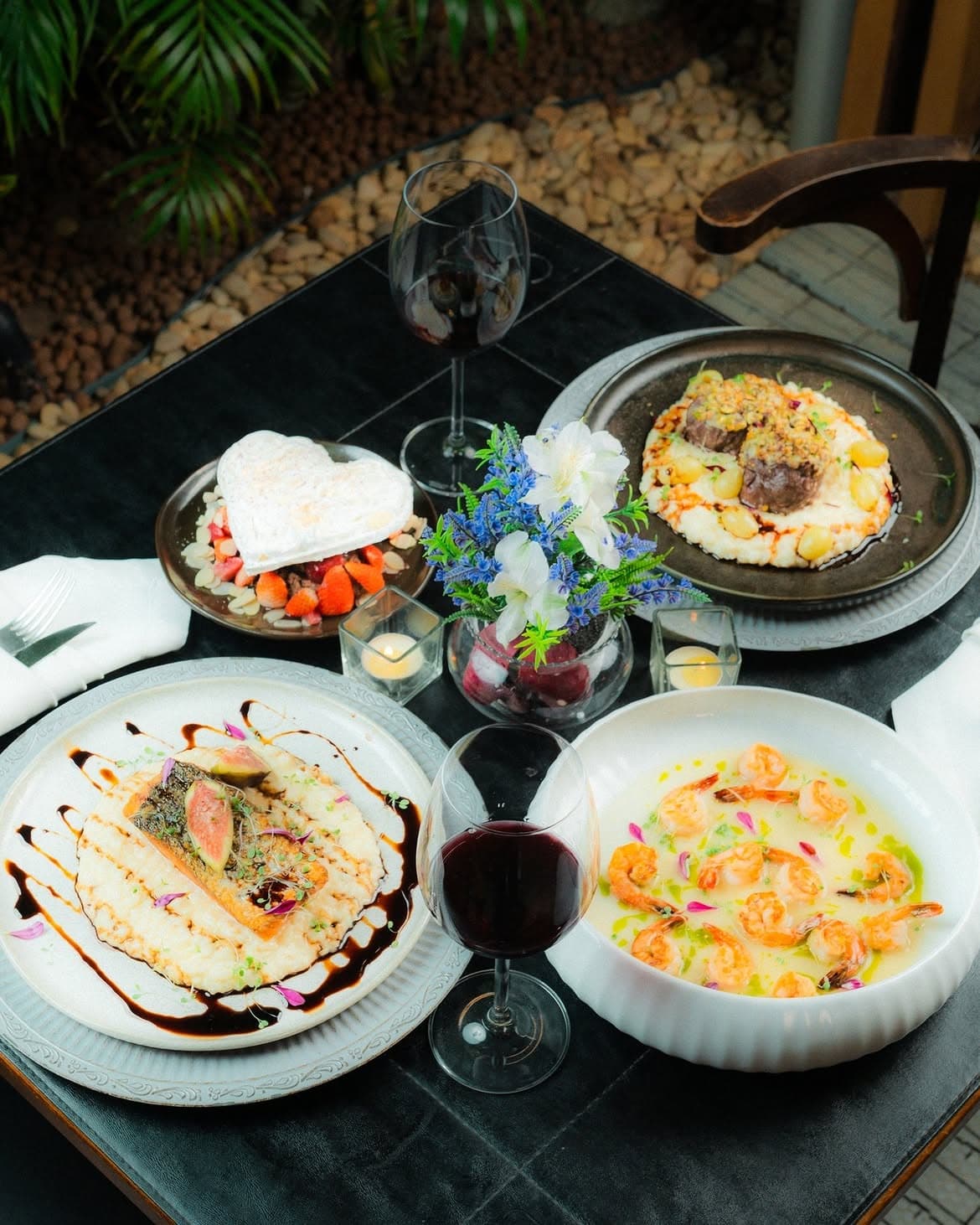 Mesa posta no jardim: risotos, camarões e vinho tinto