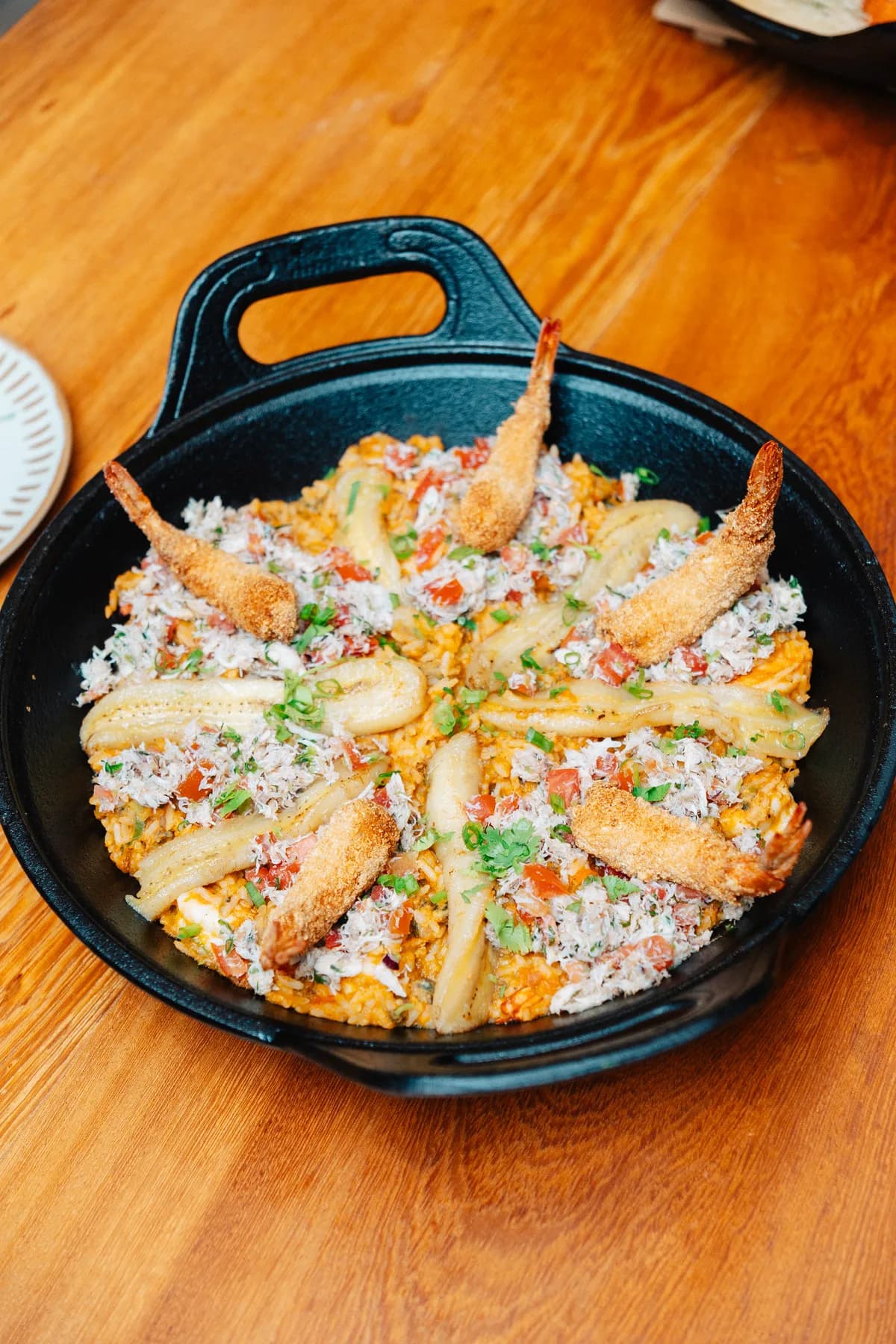 Panela de arroz com camarão empanado, banana e caranguejo desfiado, para dividir