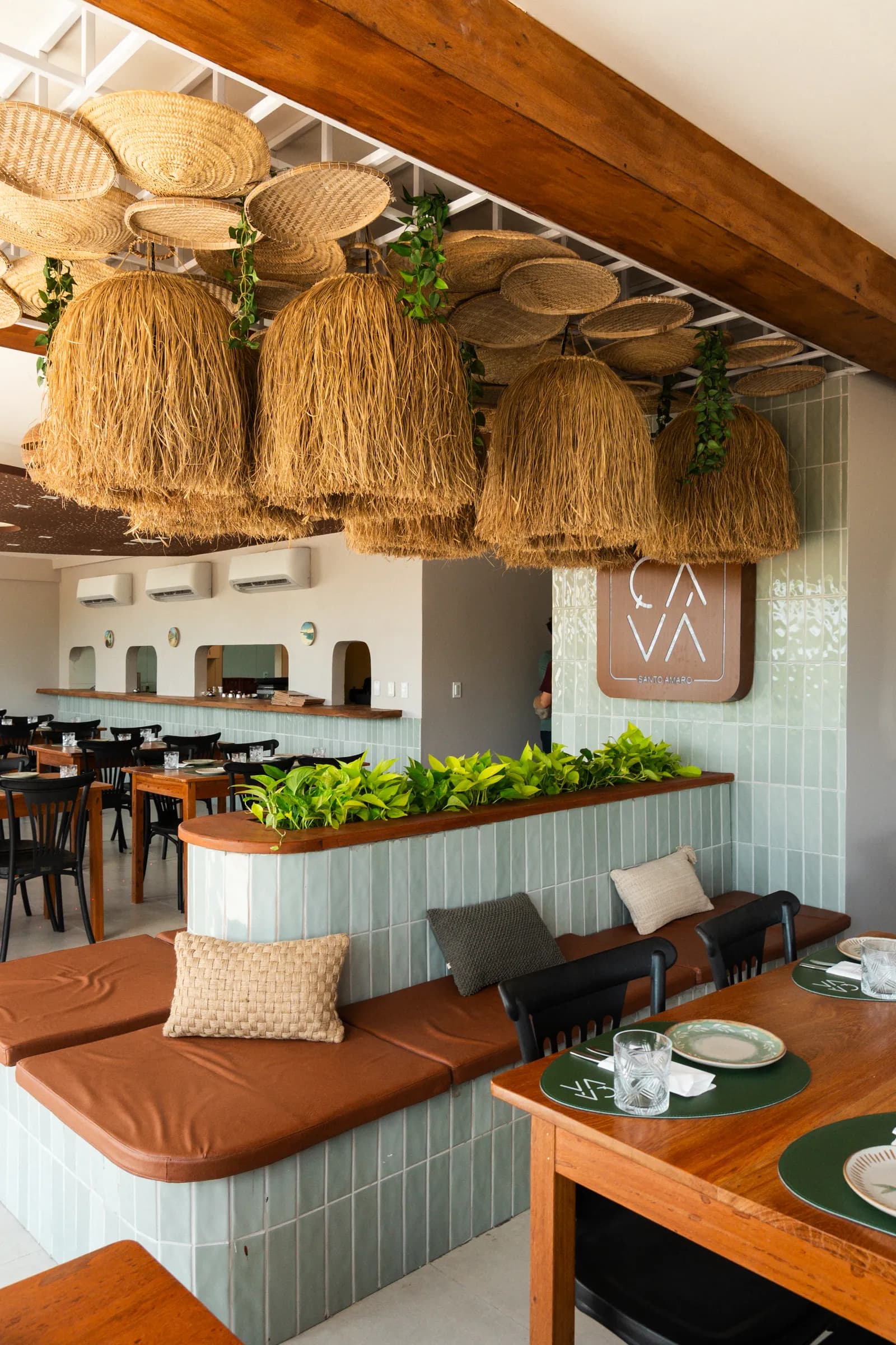 Salão do Ça-Vá Santo Amaro, com luminárias de palha e a marca da casa na parede